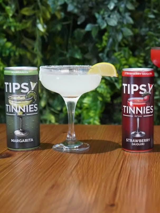 Margarita tin next to a salt rimmed coupe with a lime wedge